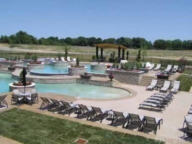 view of swimming pool featuring a hot tub