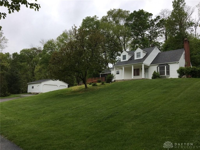 cape cod home with a garage, an outdoor structure, a front lawn, and a porch