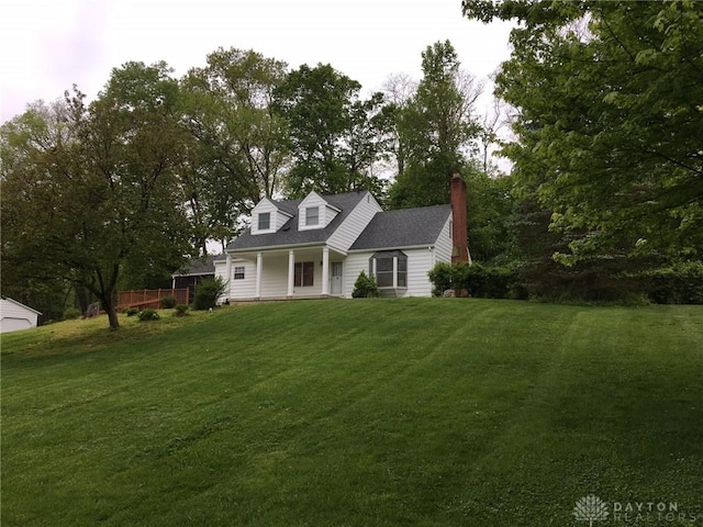 cape cod-style house with covered porch and a front lawn