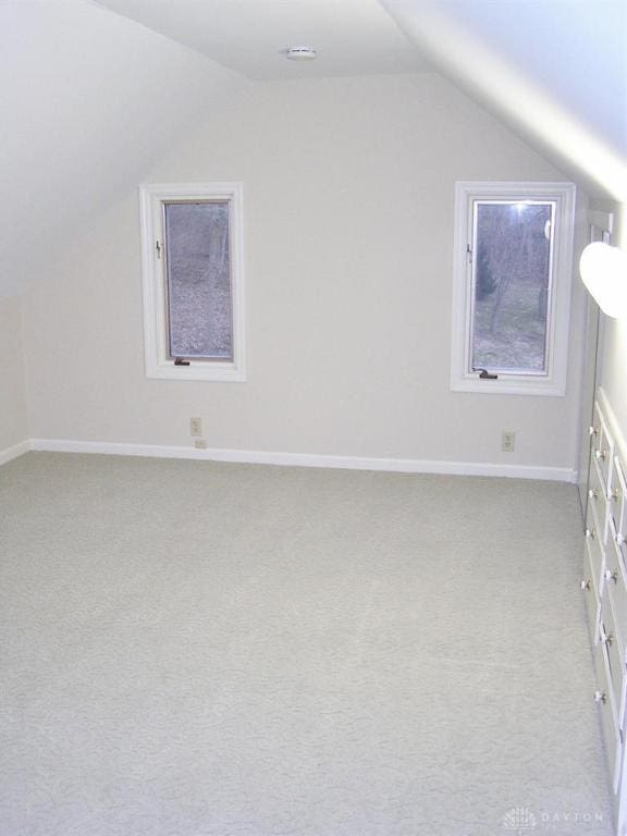 additional living space with lofted ceiling and light carpet