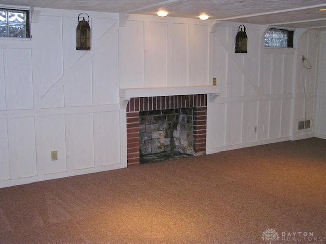 basement featuring carpet and a brick fireplace