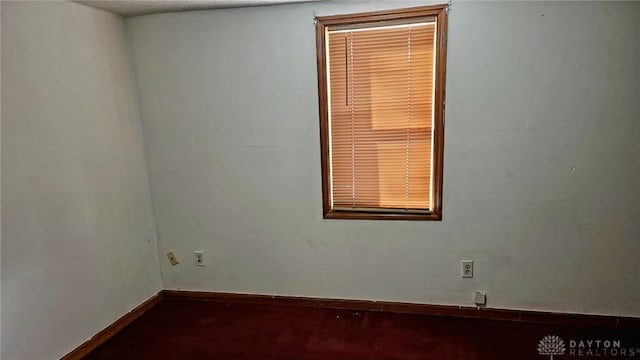 unfurnished room featuring baseboards