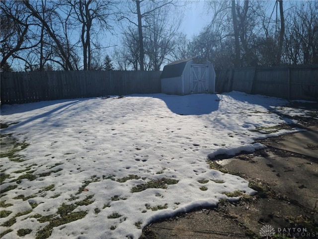 yard covered in snow featuring a shed