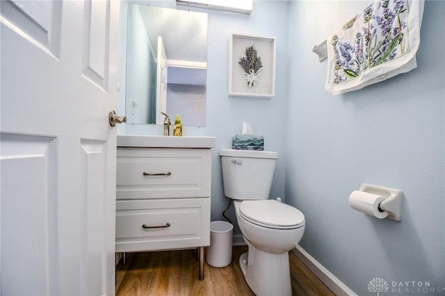 bathroom with vanity, toilet, and wood-type flooring