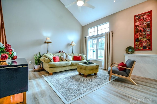 living area with wood-type flooring, ceiling fan, and high vaulted ceiling