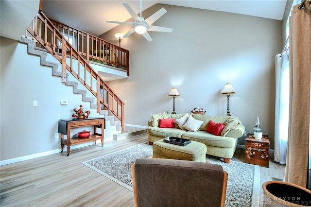 living room with ceiling fan, high vaulted ceiling, and light hardwood / wood-style floors