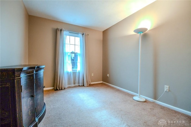 unfurnished living room with vaulted ceiling and light carpet