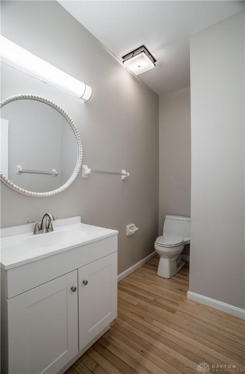 bathroom with vanity, hardwood / wood-style flooring, and toilet