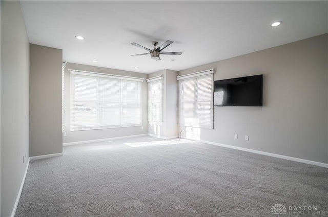 carpeted spare room featuring ceiling fan