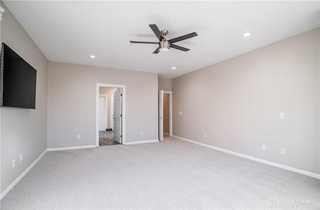 unfurnished bedroom featuring connected bathroom, light carpet, and ceiling fan