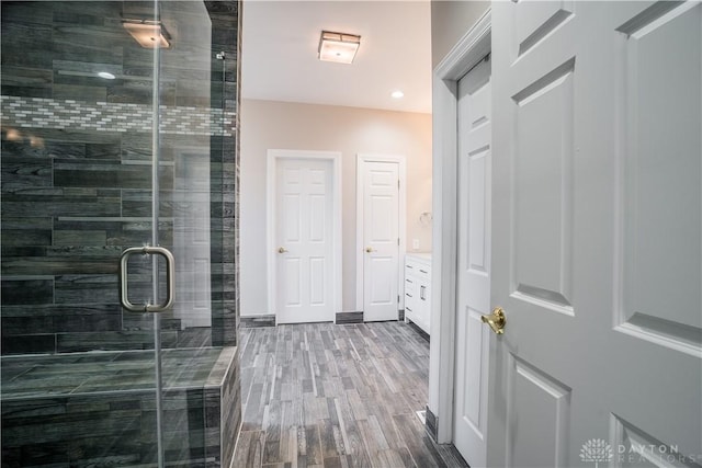 bathroom featuring hardwood / wood-style flooring, vanity, and an enclosed shower