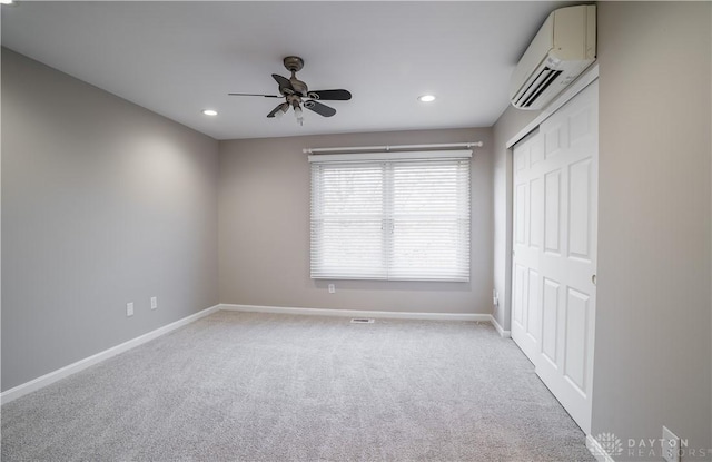 carpeted empty room featuring ceiling fan and a wall unit AC