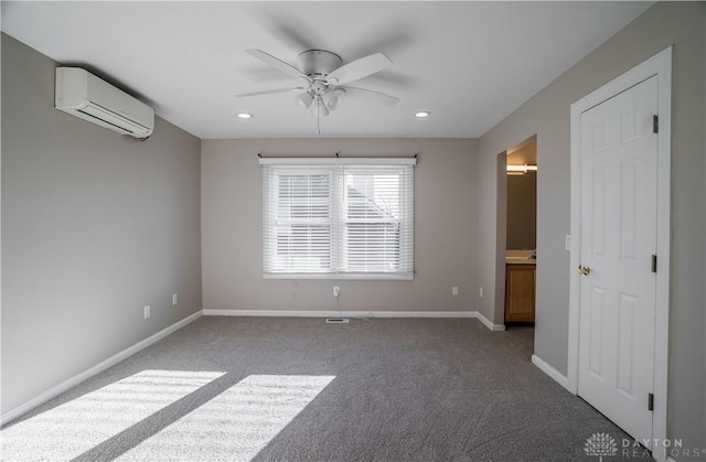 carpeted spare room featuring a wall mounted air conditioner and ceiling fan