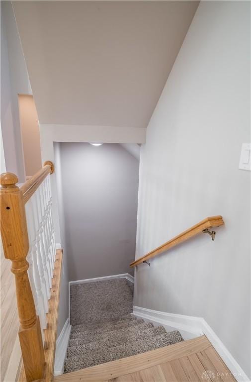 stairs with lofted ceiling and wood-type flooring