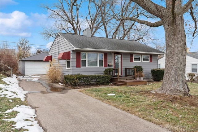 view of front of house with a garage and an outbuilding