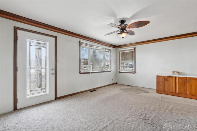 carpeted spare room featuring ornamental molding and ceiling fan