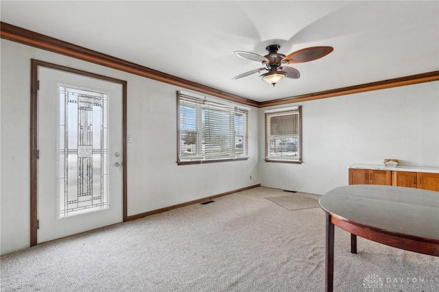 living area with crown molding, light colored carpet, and ceiling fan