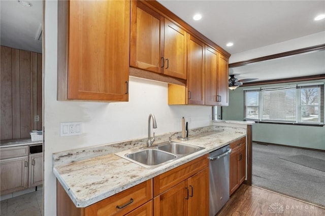 kitchen with sink, light hardwood / wood-style flooring, dishwasher, ceiling fan, and light stone counters