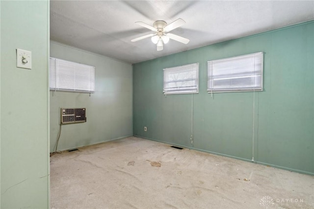 carpeted spare room with ceiling fan and a wall unit AC