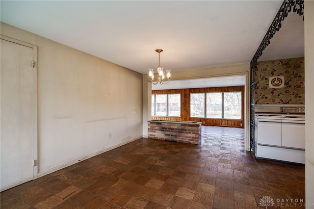 unfurnished dining area featuring dark parquet flooring and a chandelier