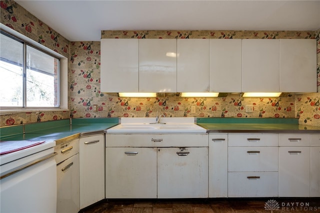 kitchen featuring white cabinetry, sink, and dark parquet flooring