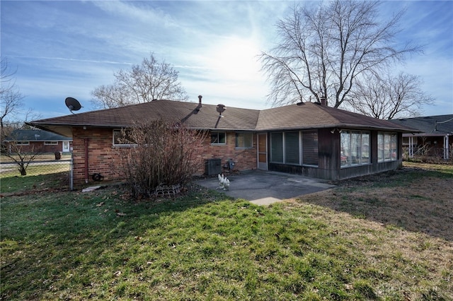 rear view of house featuring a patio, a sunroom, and a yard