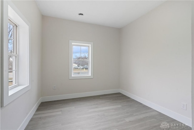 empty room featuring plenty of natural light and light hardwood / wood-style floors