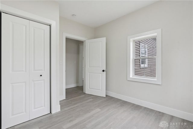 unfurnished bedroom with light hardwood / wood-style floors and a closet