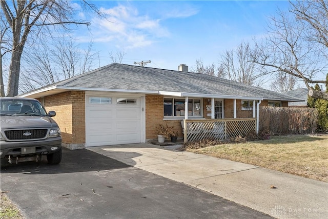 ranch-style home featuring a garage, a front lawn, and covered porch