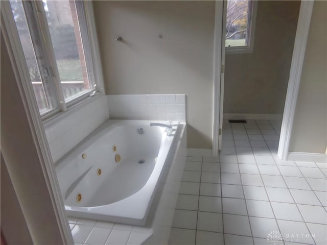 bathroom featuring a relaxing tiled tub and tile patterned floors