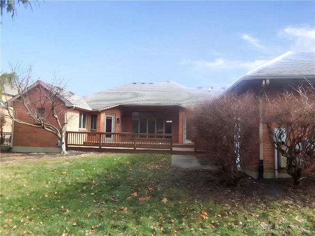 back of house featuring a lawn and a deck