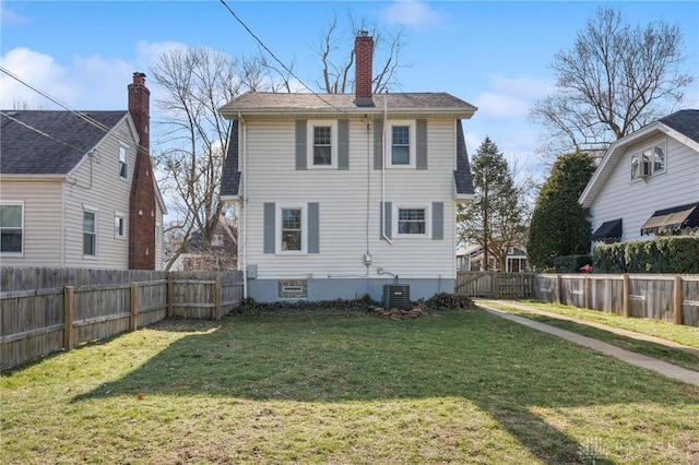 back of property with a lawn and central air condition unit