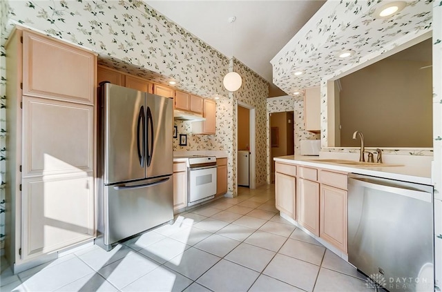 kitchen featuring sink, light tile patterned floors, light brown cabinets, and appliances with stainless steel finishes