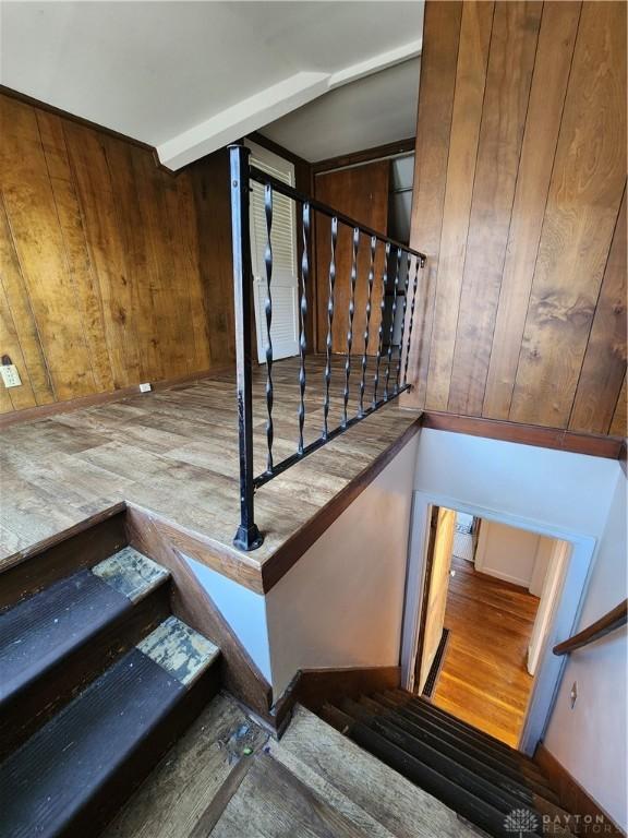 staircase featuring hardwood / wood-style flooring and wood walls