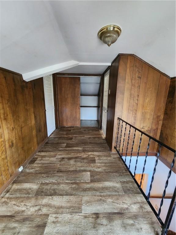 interior space with dark hardwood / wood-style floors and wood walls