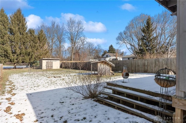 yard layered in snow with a storage unit