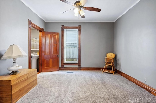 interior space featuring crown molding, light colored carpet, and ceiling fan