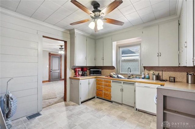 kitchen with crown molding, sink, backsplash, and white dishwasher