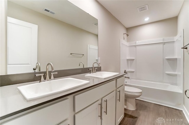 full bathroom with wood-type flooring, toilet, tub / shower combination, and vanity