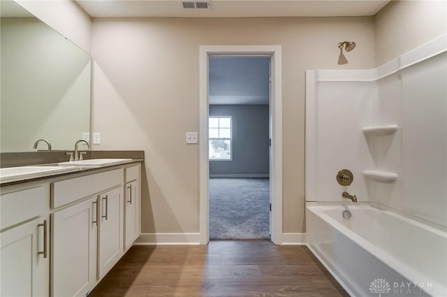 bathroom featuring vanity, wood-type flooring, and shower / bathing tub combination