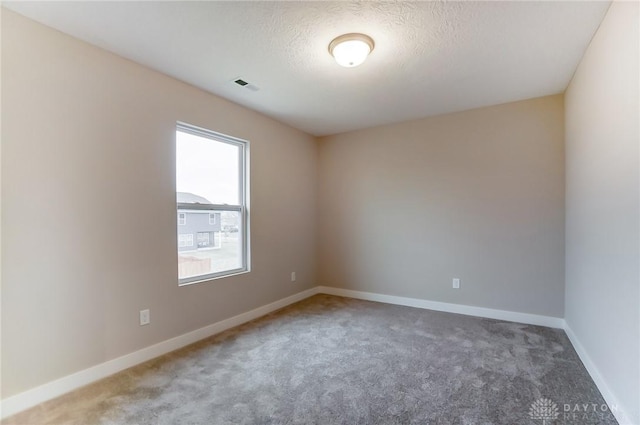 carpeted spare room featuring a textured ceiling