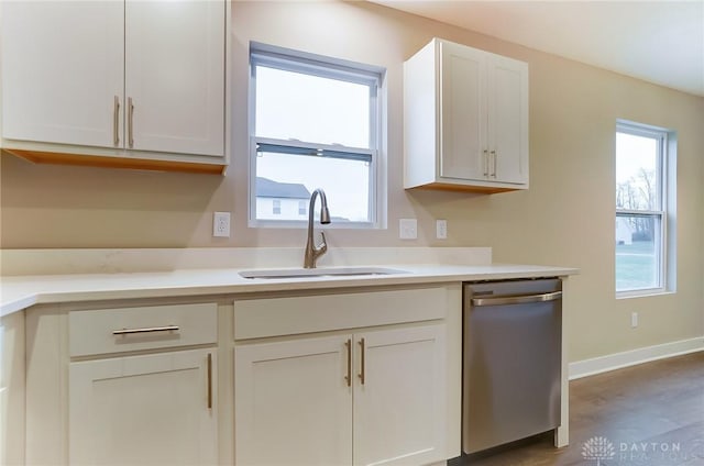 kitchen featuring white cabinetry, sink, wood-type flooring, and stainless steel dishwasher