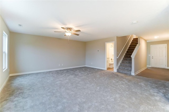 unfurnished living room featuring ceiling fan and dark carpet