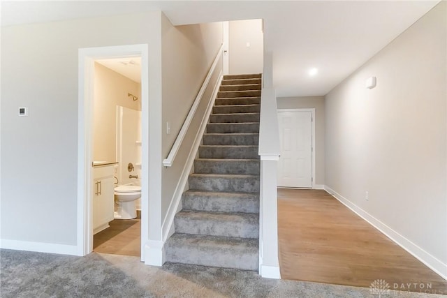 stairway featuring carpet flooring