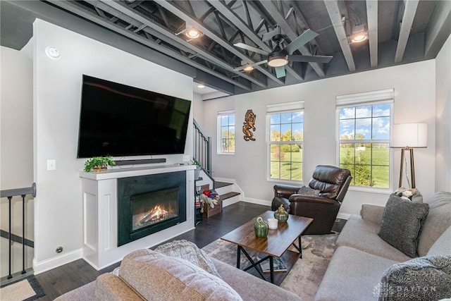 living room featuring ceiling fan, plenty of natural light, beam ceiling, and hardwood / wood-style floors