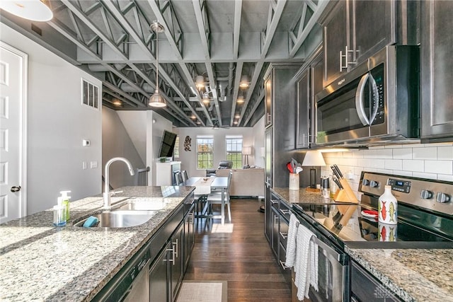 kitchen featuring light stone countertops, appliances with stainless steel finishes, and sink