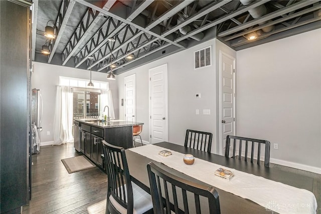 dining space featuring sink and dark wood-type flooring