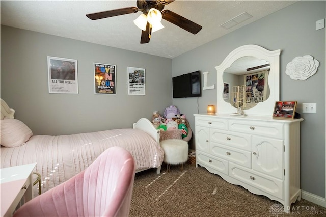 bedroom featuring ceiling fan, a textured ceiling, and dark colored carpet