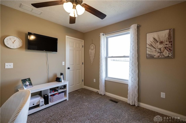 interior space with ceiling fan, carpet flooring, and a textured ceiling