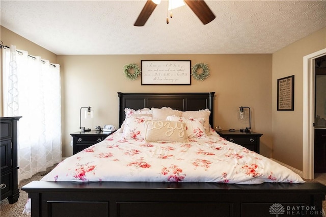 carpeted bedroom with ceiling fan and a textured ceiling